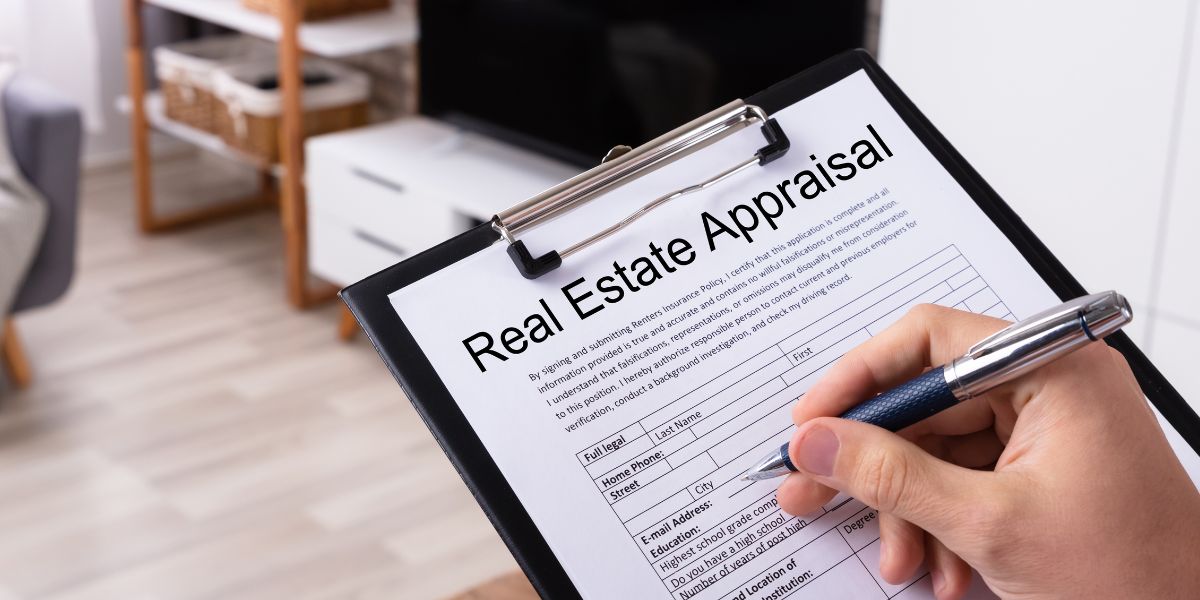 Hand holding a magnifying glass over a small model house during a home inspection.